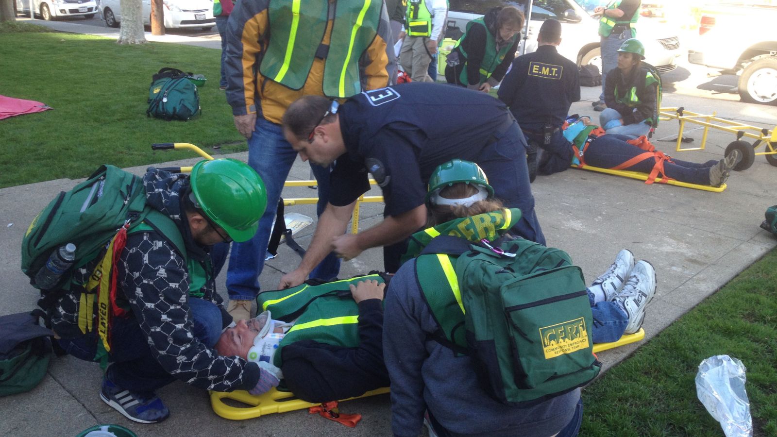 CERT volunteers practicing medical response during a training drill, including stabilization and trauma care.